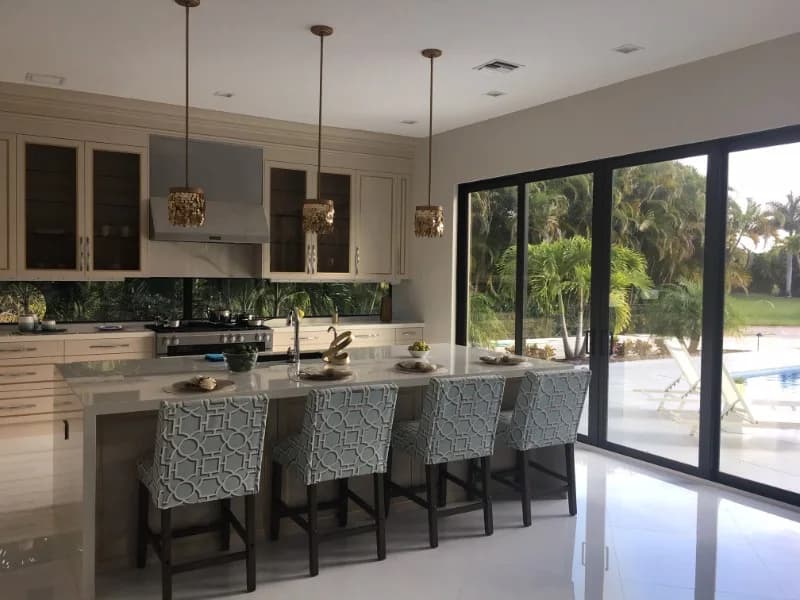 Kitchen opening to the pool through impact sliding glass