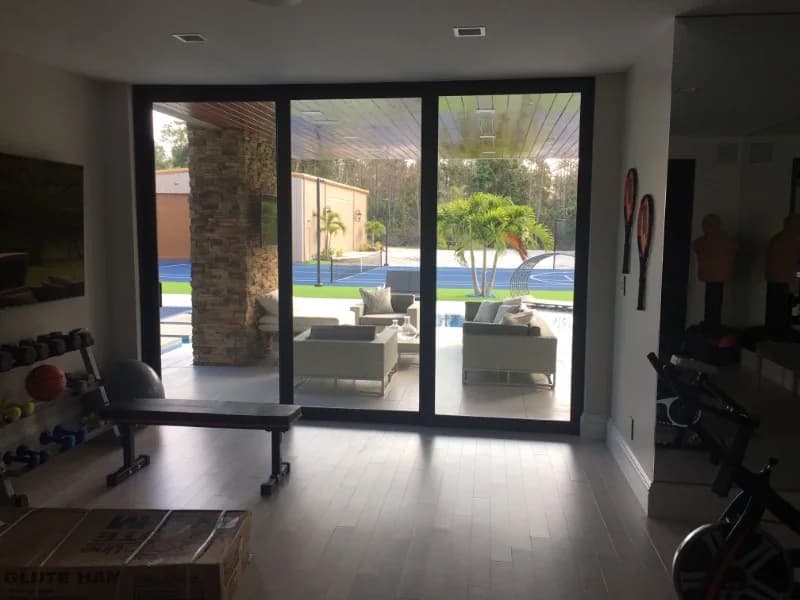 Living space with impact sliding doors onto the lawn and pool